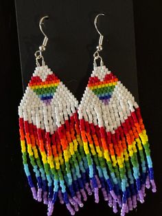 "Enhance any outfit with these vibrant "Love, Love" rainbow heart earrings. Featuring a beautiful rainbow gradient fringe, these earrings are sure to catch the eye and add a pop of color to your look. Elevate your style with these versatile and trendy accessories." Cheap Rainbow Beaded Earrings For Summer, Cheap Rainbow Beaded Earrings For Festival, Rainbow Fringe Dangle Jewelry, Rainbow Fringe Dangle Earrings, Rainbow Dangle Earrings With Fringe, Trendy Rainbow Jewelry For Pride, Rainbow Fringe Earrings As Gift, Rainbow Tassel Earrings For Gifts, Multicolor Fringe Jewelry As A Gift