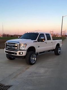 a white pickup truck parked on the side of a road in front of power lines