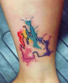 a woman's foot with a colorful tattoo on it