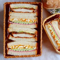 two baskets filled with sandwiches on top of a table