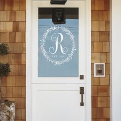 a white door with the letter r on it and a wreath in the center is shown