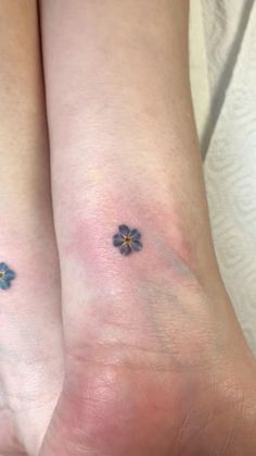 two small blue flowers on their legs