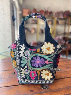 an embroidered bag sitting on top of a wooden table