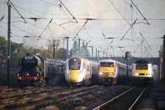 three trains traveling down train tracks next to each other