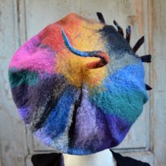 To brighten up your wardrobe I made this artist beret,  I have tried to create strokes of paint with wool. I have used tones of green, red, purple, yellow, orange, grey, black and blue Merino wool. I have incorporated the merino wool like an artist would use his paints, to produce a unique one of a kind art beret. one of the  photo's showing a similar beret on my model. On top is a spike of color and around the brim I have machine stitched the edge and added a arty pin which is machine stitched to the brim of the hat. ♥This Hat is ready to ship. Every hat I make is a unique piece, therefore, if I make more than one of the same design yours will be unique in itself, because it is hand-made. Your hat will, of course, be very close to the original in the photograph, so you can be assured the Handmade One Size Beret, Artistic Multicolor Cap, Multicolor Flat Cap For Fall, Multicolor Beanie Hat For Gift, Multicolor Beanie Hat Gift, Artistic Handmade Hat As Gift, Handmade Artistic Hat As Gift, Artistic Handmade Hats As Gift, Whimsical Multicolor Hats For Gifts