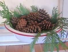 a white bowl filled with pine cones on top of a wooden floor next to a door