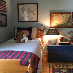 a bed room with a neatly made bed and a teddy bear sitting on top of it