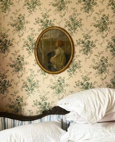 a bed with white pillows and a painting on the wall