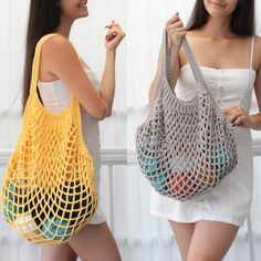 two women are standing next to each other and one is holding a crocheted bag