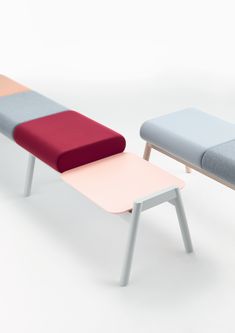 three different colored benches sitting next to each other on a white surface with one bench in the middle