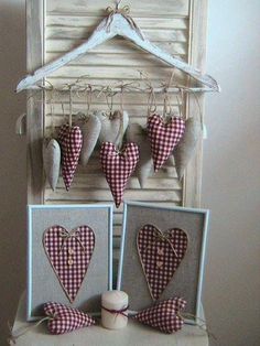 two hearts are hanging on the clothesline in front of a window with an orange and white checkered ribbon