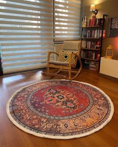 a living room with a rocking chair, rug and bookshelf