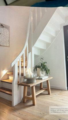 there is a table with candles on it next to the stairs in this house,