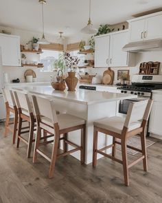 a kitchen with white cabinets and wooden floors