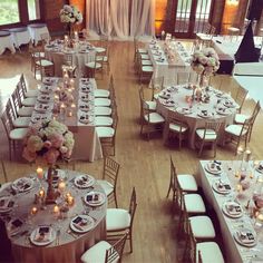 the tables are set up with white linens and silverware for an elegant wedding reception