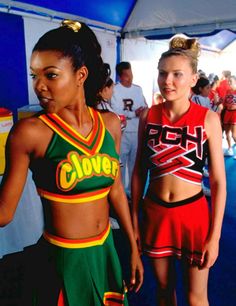 two young women in cheerleader outfits standing next to each other at a movie event