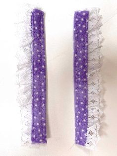 two pieces of purple and white lace with dots on them are laying next to each other