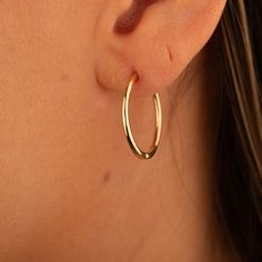 Our 14K Gold Skinny Hoop Earrings offer a timeless design, combining sleek elegance with everyday functionality. These classic hoops are crafted from genuine 14K solid gold, providing durability and a lasting shine that will complement any wardrobe. With an outside diameter of 21.5mm and an inside diameter of 19mm, these earrings are designed to be lightweight and comfortable, making them perfect for daily wear or special occasions. The slender thickness of 1.65mm ensures they remain subtle yet noticeable. Key Features: Sleek Design: Features a slender profile, perfect for adding a touch of elegance to any outfit. High-Quality Material: Crafted from genuine 14K solid gold, ensuring both elegance and long-lasting wear. Lightweight Comfort: Designed with a thickness of 1.65mm for a comfortab Minimalist Yellow Gold Hoop Earrings With Shiny Finish, Delicate Tarnish-resistant 14k Gold-filled Hoop Earrings, Chic 14k Gold-filled Yellow Gold Hoop Earrings, Elegant Gold-tone 14k Gold-filled Hoop Earrings, Hypoallergenic 14k Gold-filled Hoop Earrings, Gold Heart Ring, Love Ring, Heart Bracelet, Exquisite Jewelry