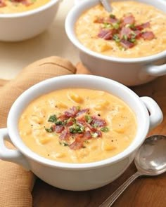 two white bowls filled with soup on top of a wooden table