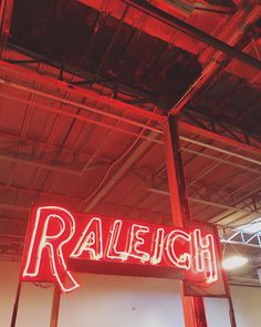 a red neon sign that says raileih hanging from the ceiling