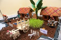 a small garden with miniature farm animals and people