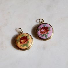 Vintage Yellow or Purple Round Locket Charm This round functioning locket charm features a vintage rose enamel cabochon estimated to have been produced in Japan in the 1950s. The locket is 20mm wide/tall and about 5mm thick. The locket base is made of raw brass and has a loop at the top for threading on a delicate chain or use in other jewelry creation. Vintage Enamel Jewelry With Vintage Charm, Vintage Enamel Charms Jewelry, Vintage Enamel Collectible Jewelry, Vintage Enamel Jewelry For Collectors, Vintage Rose Design Pendant Jewelry, Vintage Pink Jewelry For Keepsake, Vintage Pink Keepsake Jewelry, Vintage Charm Round Enamel Jewelry, Vintage Nickel-free Enamel Necklaces