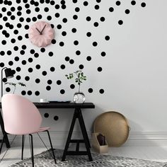 a black and white polka dot wallpaper with pink chair next to it in front of a desk