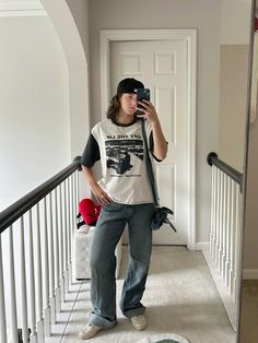 a woman taking a selfie while standing on the stairs in front of a door