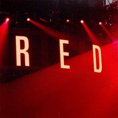 the word red is lit up on stage with spotlights