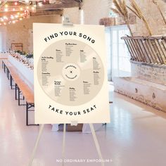 a sign that says find your song take your seat in front of a long table