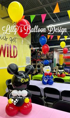 mickey mouse balloon decoration in the middle of a table at a children's birthday party