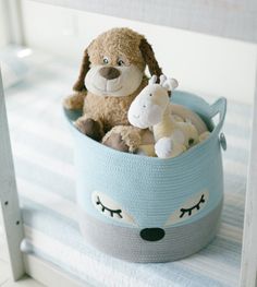 a stuffed animal sitting in a blue basket