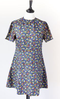 1960s handmade  mini dress in a blue acetate fabric patterned with grape vines. The shape is close fitted in the body with a drop waist flared skirt. The seams in the bodice (see close-up photo) give the dress a well structured fit. PLEASE NB: The round neck sits high as seen on the mannequin. There is no size label. In my opinion the fit is  a UK 10 The garment is a light-mid weight Excellent Condition. Bright Clean Fresh Colour. No Notable Flaws. FLAT Measurements (Un-stretched) (1 cm = 0.39 i Retro Fitted Floral Print Mini Dress, Retro Fitted Mini Dress With Floral Print, Blue Fitted Mod Mini Dress, Vintage Fitted Blue Mini Dress, Vintage Blue Short Sleeve Mini Dress, Blue Vintage Short Sleeve Mini Dress, Fitted Mod Floral Print Dresses, Fitted Mod Dress With Floral Print, Blue A-line Mod Dress