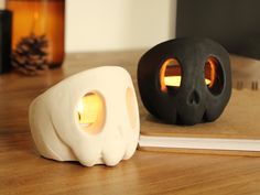 there is a book with a skull on it and a candle holder in the shape of a skull