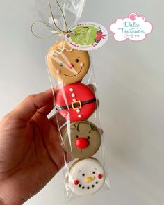 a hand holding a package of decorated cookies