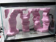 some pink rocks in a glass case on top of a paper toweled countertop