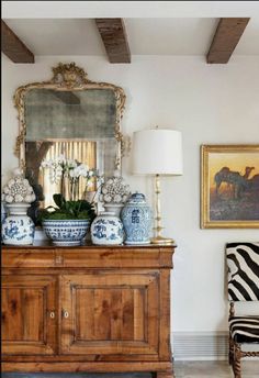 a living room with blue and white vases on top of a dresser