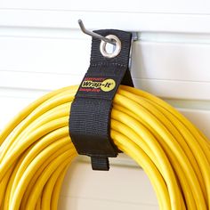 a yellow hose hanging on the side of a wall