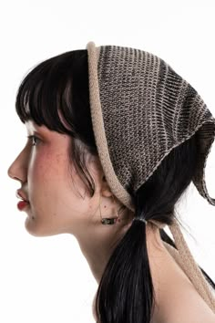 a woman with black hair wearing a brown and white knitted head wrap on top of her head