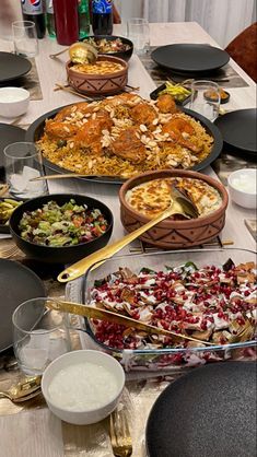 a table filled with lots of different types of food on top of plates and bowls