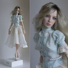 a doll with blonde hair wearing a white dress