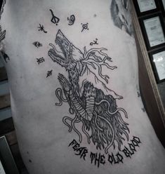 a man with a tattoo on his back that says fear the old days and an image of a wolf