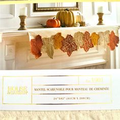 a white mantle with fall leaves and pumpkins on it