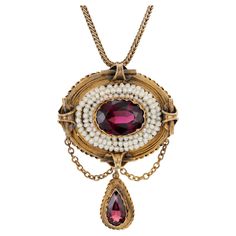 Antique, early 1800's garnet and pearl domed pendant necklace. Oval garnet center stone with a 3 row halo of pearls, set in 14k yellow gold with a pear shaped garnet dangle. 18 inch 14k yellow gold chain. One genuine reddish Garnet, approx. total weight 3.50cts, VS, 12 x 9 oval One genuine pear Garnet, approx. total weight 1.30cts Approx. 50 natural drilled pearls 1.5mm 14k Yellow Gold 13.3 grams Top to bottom: 44.45mm or 1.75 inches Width: 31.31mm or 1.23 inches Depth: 12.80mm Length: 18 inches 1800s Jewelry, Garnet And Pearl, Lalique Jewelry, Ruby Necklace Pendant, Sabyasachi Jewellery, Antique Pendant, Natural Pearl, Yellow Gold Chain, Fantasy Jewelry