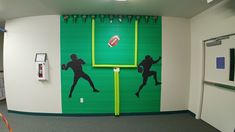 a room with a green and white wall painted to look like a football game scene