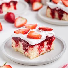 a piece of strawberry poke cake on a plate with strawberries around it and the rest of the cake in the background