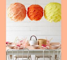 paper lanterns are hanging from the ceiling above a table