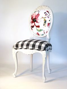 a white chair with a black and white checkerboard seat cover on the back