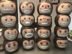 a group of wooden dolls with faces painted on them sitting next to each other in front of a mirror