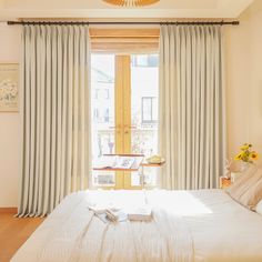 a bedroom with a large bed and white curtains